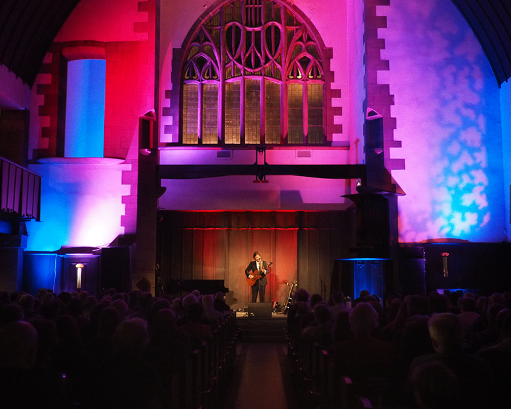 the stage inside the Mackintosh Church with an audience and performer