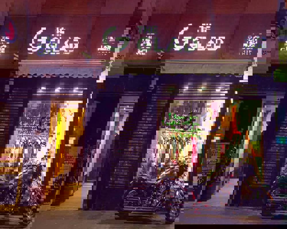 a view of the Glad Cafe from the street with motorbike in front of window. 