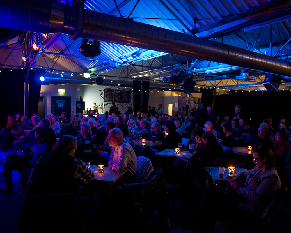 Drygate concert during Celtic Connections. Audience sitting at candle lit tables. 